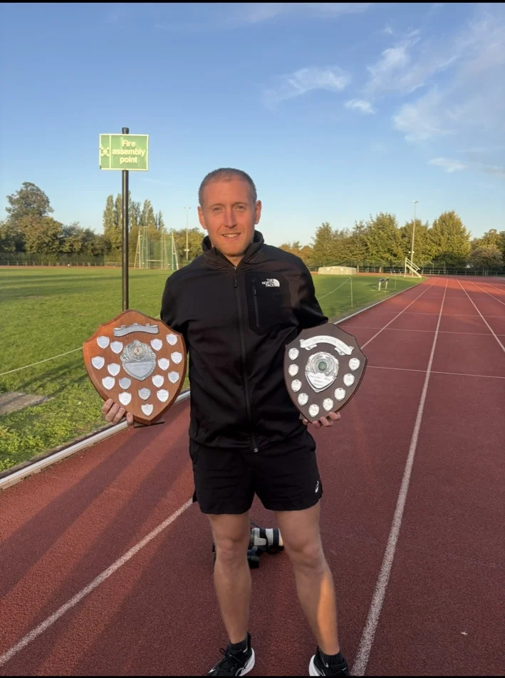 Fortify coach holding athletics award shields